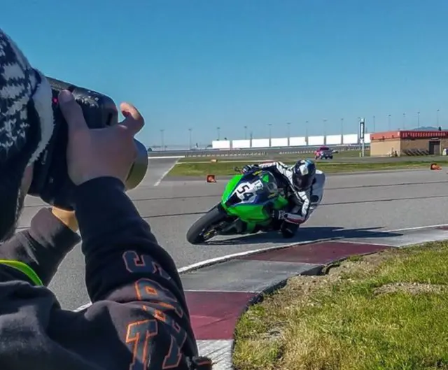 Photo of a photographer taking a picture of a motorcycle rider.