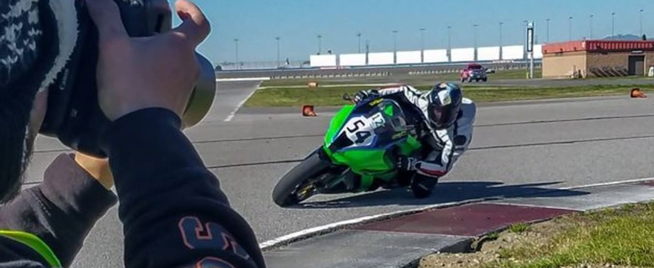 Photo of a photographer taking a picture of a motorcycle rider.