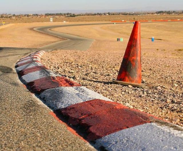 A photo of a track at Willow Springs with an orange traffic cone.